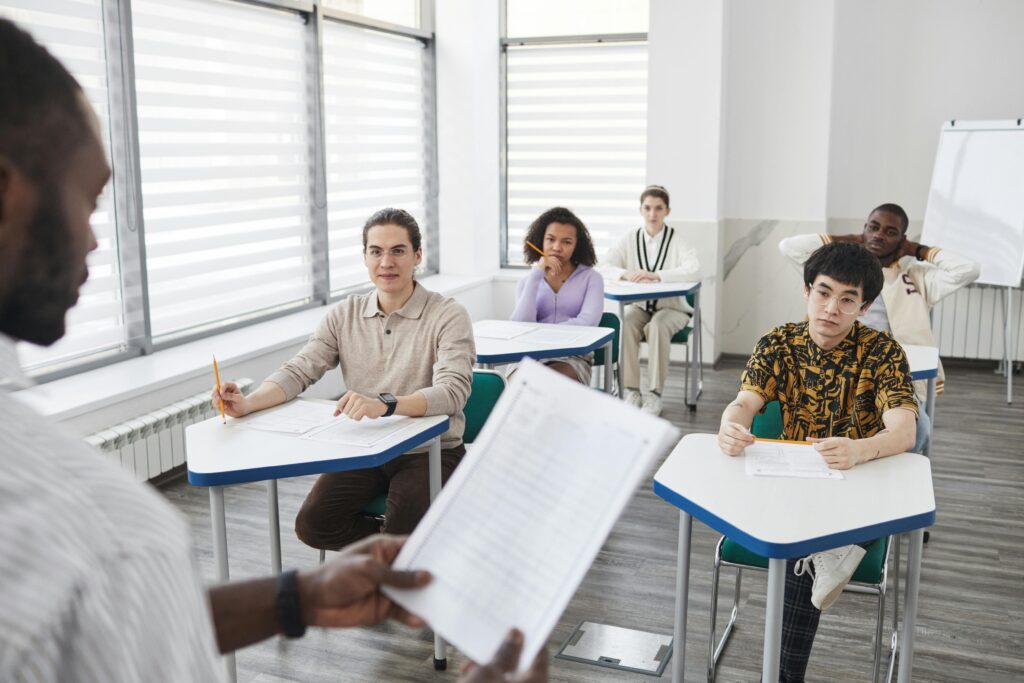 A diverse group of students attentively taking an exam in a classroom setting.